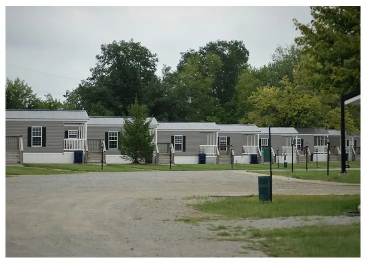 A row of mobile homes in the middle of a lot.