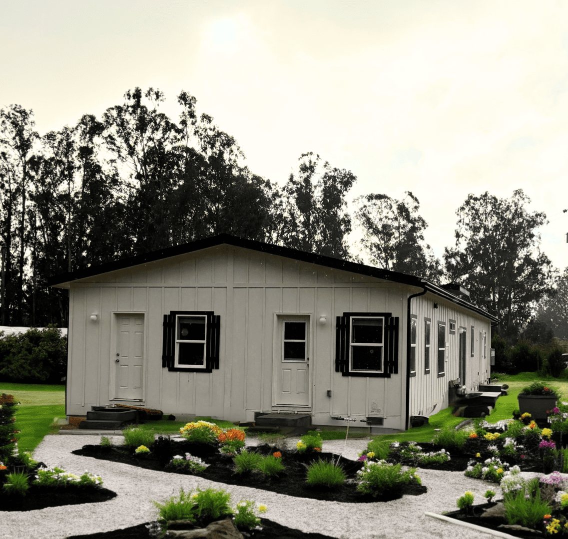 A white house sitting in the middle of some flowers - setup and installation project by Cravens Manufactured Homes