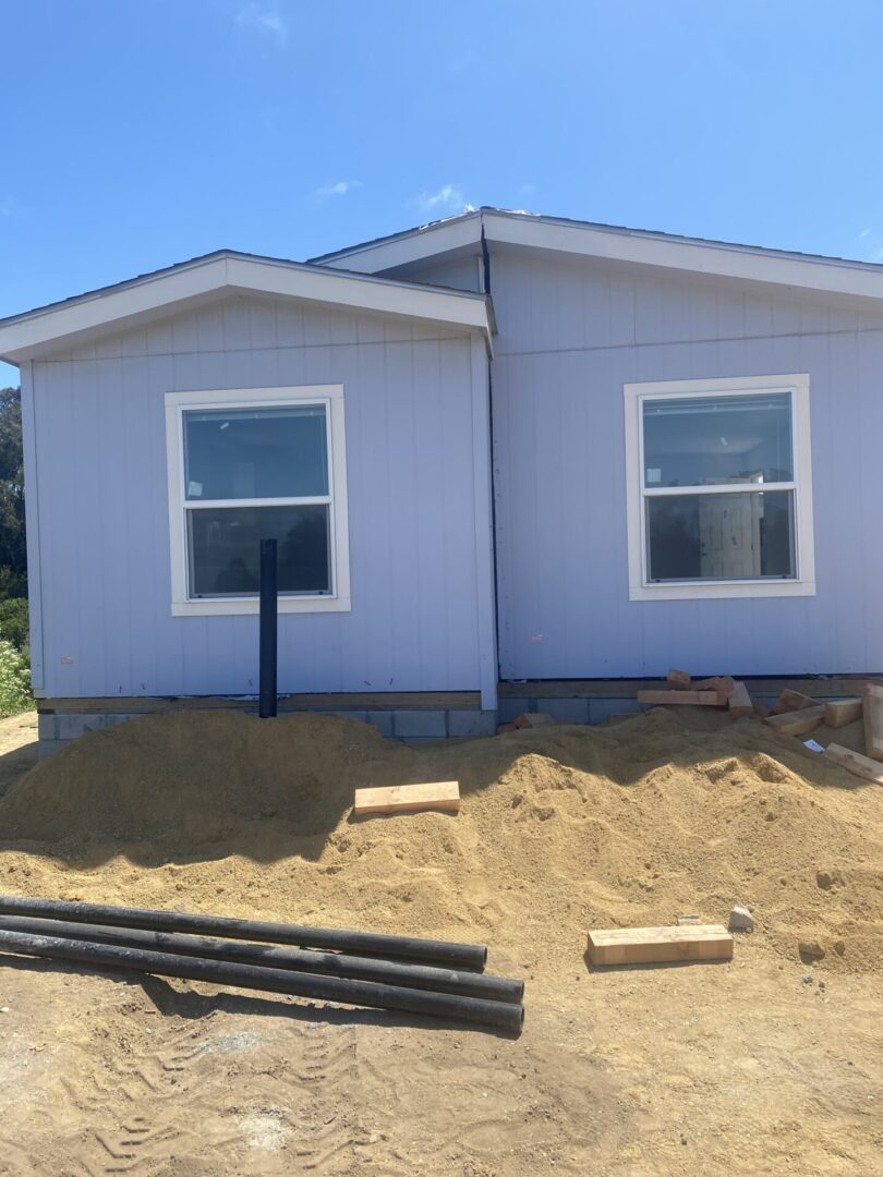 A house that is being built in the dirt. Small cottage-style manufactured home model for sale in Paso Robles